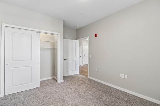 A room with a white door and carpeted floor.
