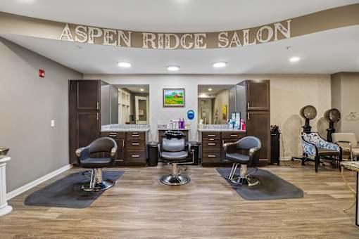 A salon with chairs and a counter with a sign that says "Aspen Ridge Salon".