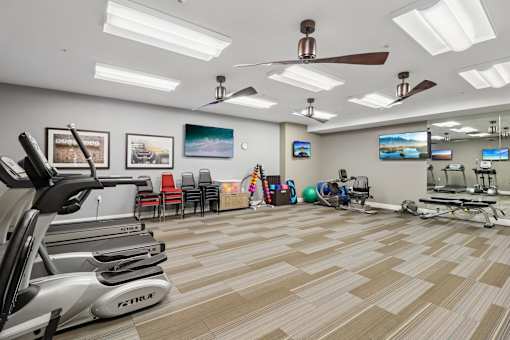 A gym with treadmills, exercise balls, and other equipment.
