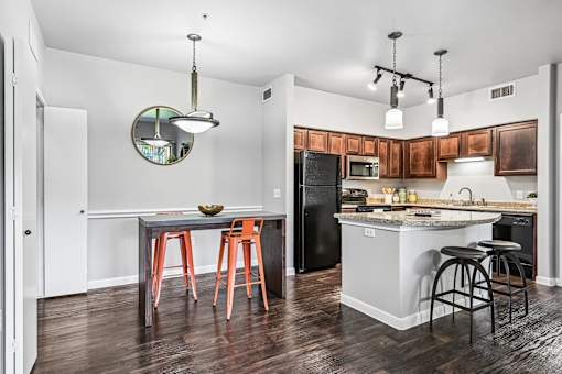 A kitchen with a table and chairs and a fridge.