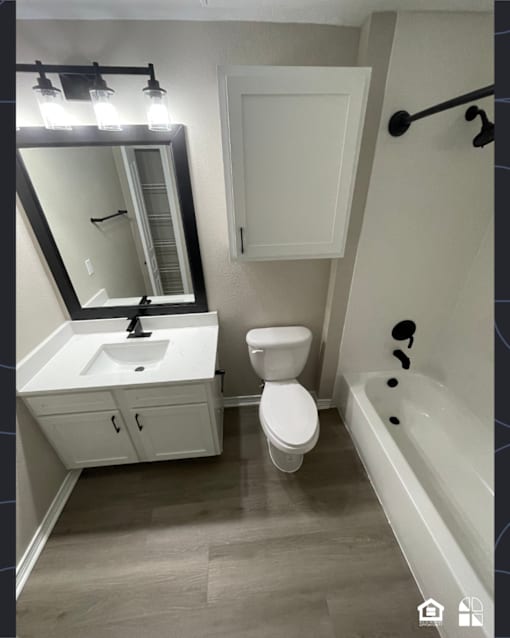 A white bathroom with a sink, toilet, and bathtub.