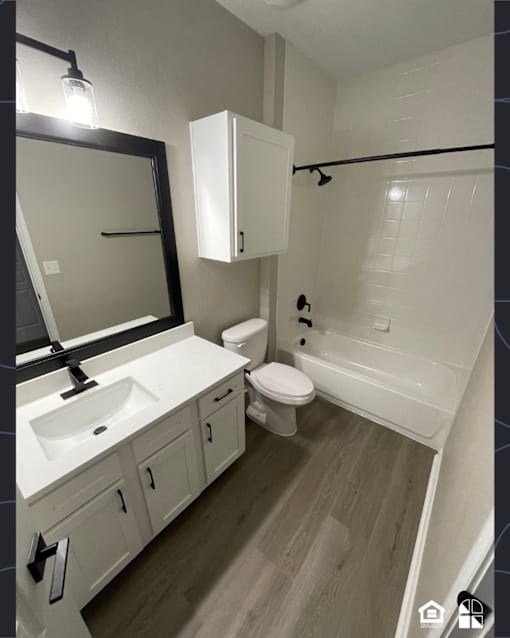 A bathroom with a sink, toilet, and bathtub.