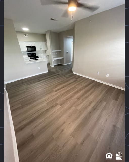 A room with wooden flooring and a ceiling fan.