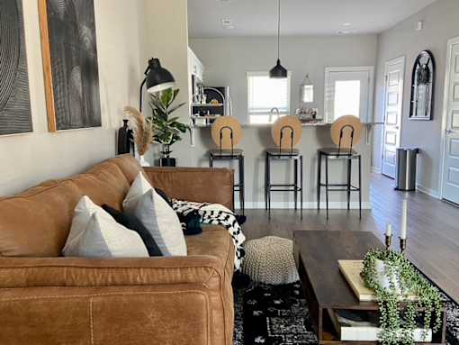 a living room with a brown couch and a wooden coffee table