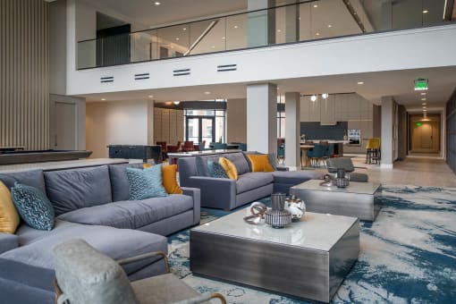 two groups of gray couches around square coffee tables in an indoor atrium room at The Apex at CityPlace, Kansas