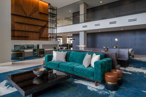 long, teal couch in front of a black, square coffee table in a large room at The Apex at CityPlace, Overland Park