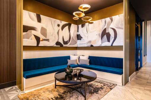 blue corner booths with a black table and large paintings on the walls at The Apex at CityPlace, Overland Park, KS