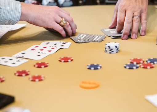hands playing with cards and poker chips on a table at The Apex at CityPlace, Kansas