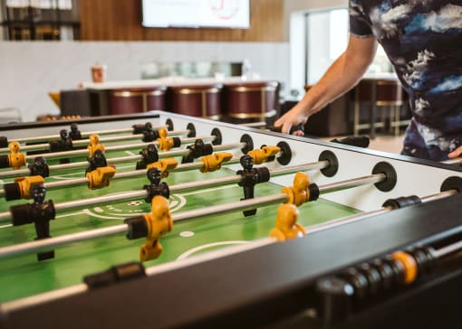close up of a man playing foosball indoors at The Apex at CityPlace, Overland Park