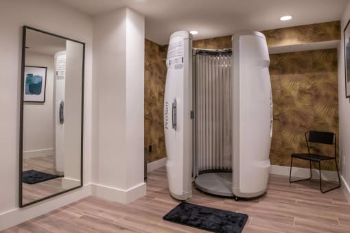 Prosun tanning bed in a room with a chair and full length mirror at The Apex at CityPlace, Overland Park, KS