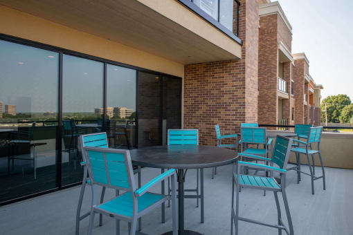 outdoor circular tables with blue chairs on a patio at The Apex at CityPlace, Overland Park