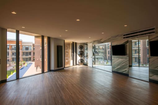 studio space with hardwood floors, ceiling to floor mirrors and windows, and some workout equipment at The Apex at CityPlace, Overland Park, KS