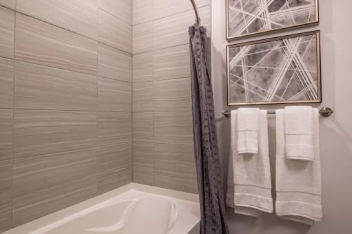 a tub with a shower curtain and towels in a bathroom at The Apex at CityPlace, Kansas