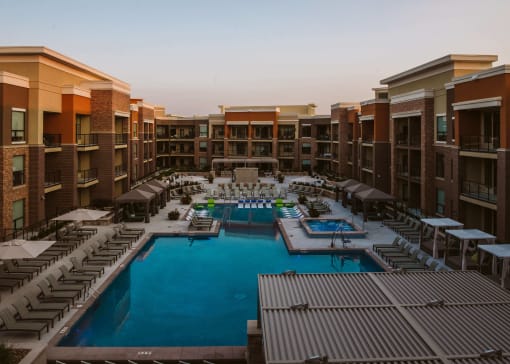 aerial view of apartment complex with a pool and outdoor seating in the center at The Apex at CityPlace, Kansas, 66210