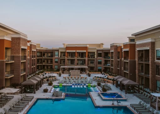 zoomed out aerial view of outdoor pool and chairs around it in the center yard of an apartment complex at The Apex at CityPlace, Overland Park, 66210