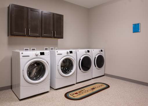 A community laundry room with four machines at Aspen Ridge 55+ Active Adult Community