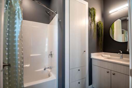 A bathroom with a white tub and sink.
