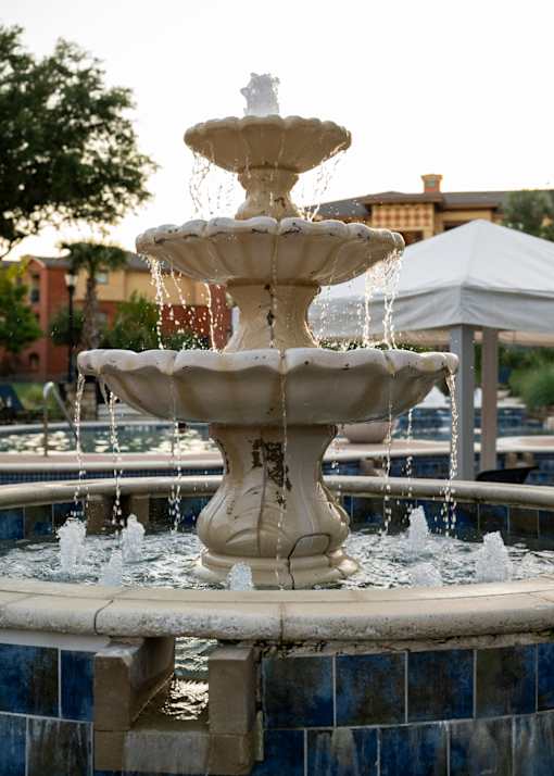 A white fountain with water spraying out of it.