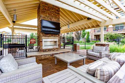A patio with a fireplace and seating area.