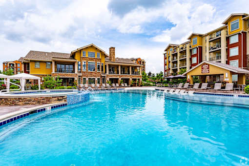 A large swimming pool in front of a resort.
