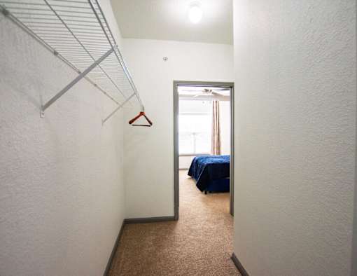 A room with a bed and a hanger on the wall.
