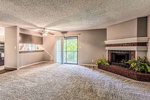 A living room with a fireplace and a ceiling fan.