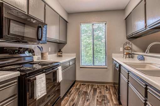 A kitchen with a stove top oven and a microwave above it.