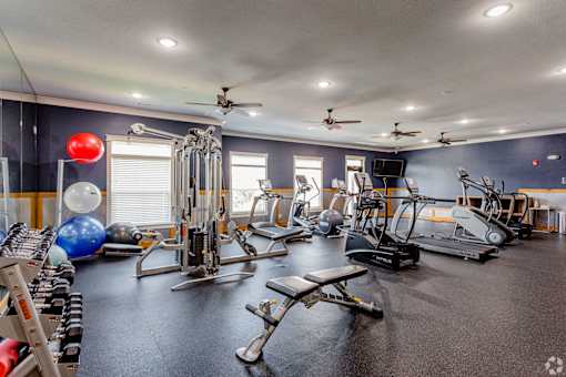 A spacious gym with a variety of equipment including treadmills, weights, and exercise balls.