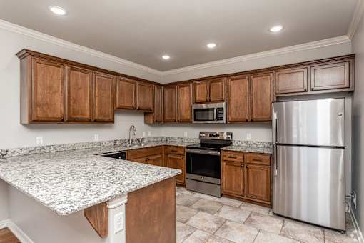A kitchen with wooden cabinets and a granite countertop.