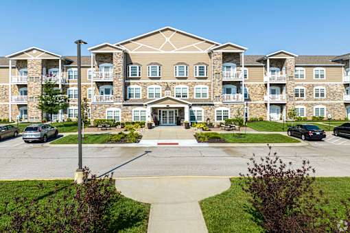 A large apartment building with a parking lot in front.
