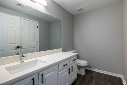 A bathroom with a white sink and toilet.