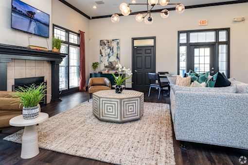 A living room with a fireplace and a grey couch.