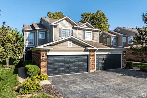 A large house with a grey garage door.