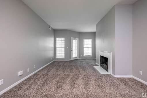 A room with a fireplace and carpeted floor.