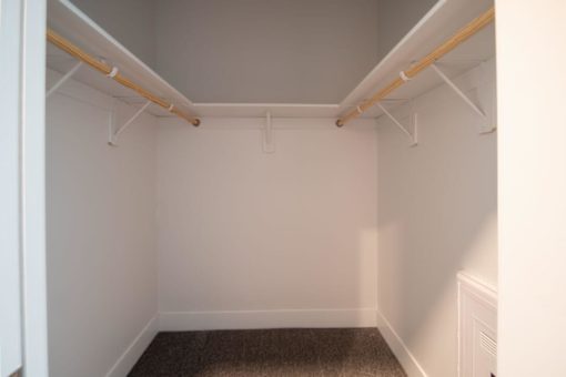 A white room with a brown carpet and white walls.