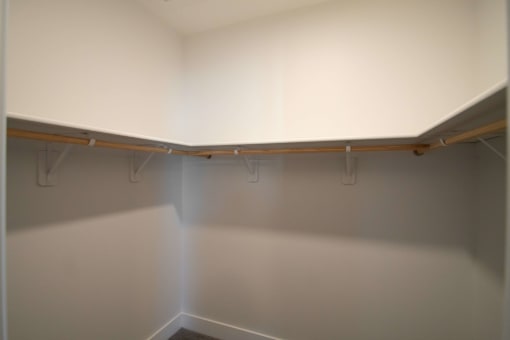 A white closet with a light shining through the door.