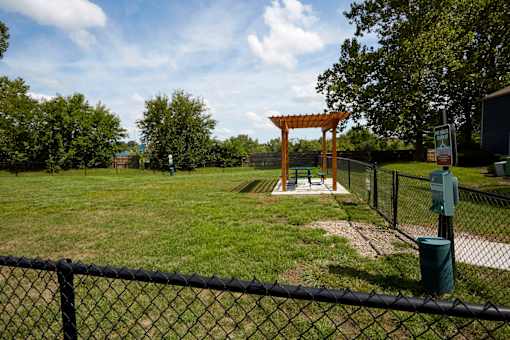 A park with a swing set and a fence.