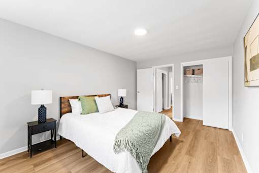 A bedroom with a bed, nightstand, and lamp.