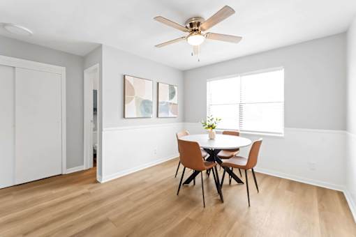 A dining room with a table and chairs.