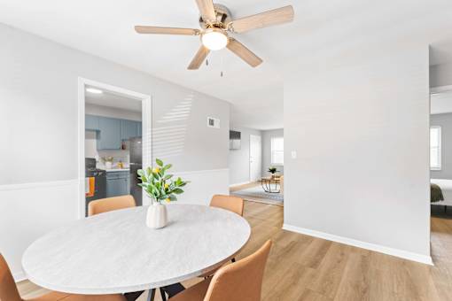 A dining room with a white table and chairs.