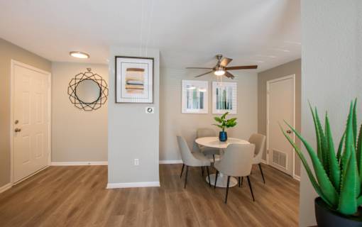 A dining room with a table and chairs.