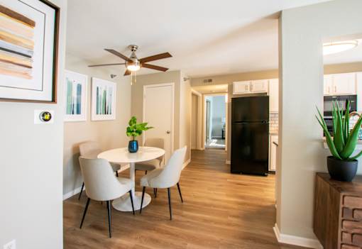 A dining room with a white table and chairs.