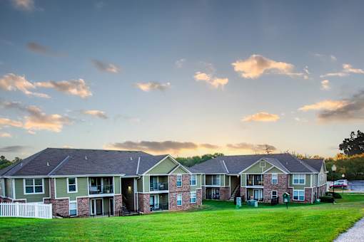 A row of houses with a white picket fence in front.