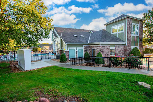 A house with a grey roof and a white fence.