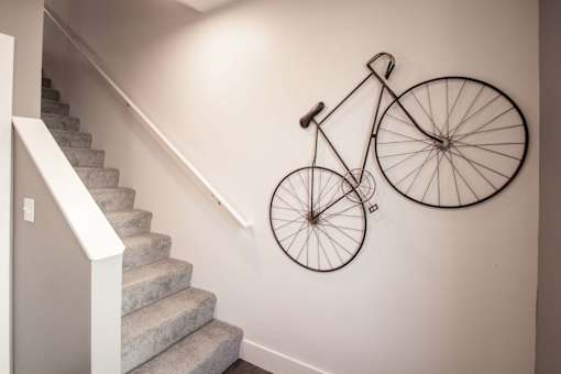 A bicycle is mounted on the wall above a staircase.