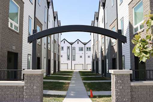 A row of modern houses with a black archway in the foreground.