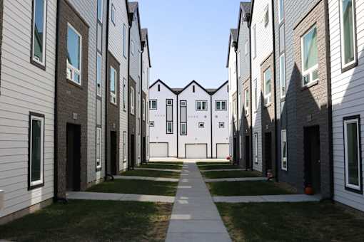 A long row of modern houses with white and brown exteriors.