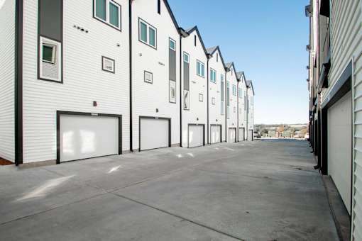 A row of white houses with black shutters and doors.
