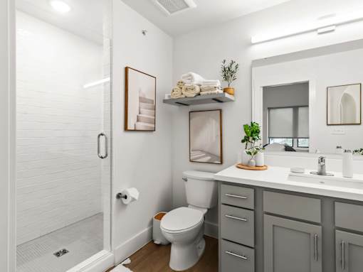 A white bathroom with a toilet, sink, and mirror.