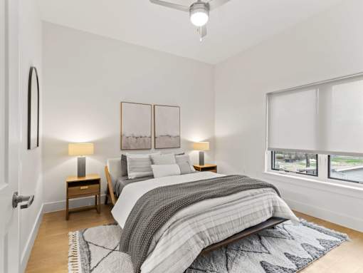 A bedroom with a large bed and two lamps.